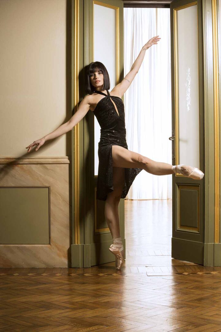 A photo of a ballerina posing in a doorway.