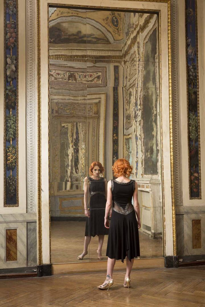 A woman is standing in front of a mirror.