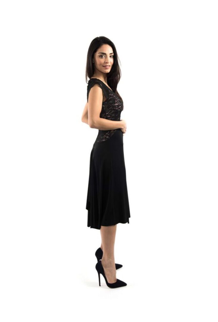 Woman standing sideways wearing a black dress