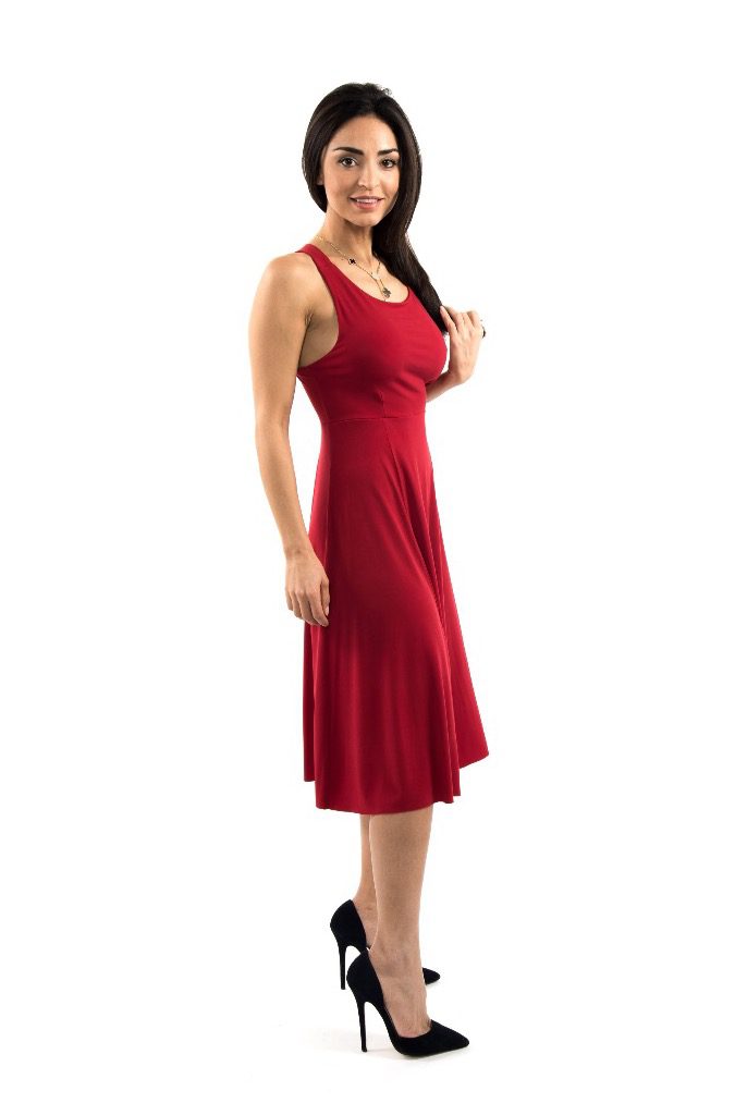 A woman wearing a red dress and black heels side view