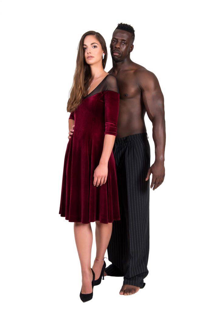 A woman in a red timeless tango dress in velvet with a man