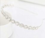 A white headband with crystals on it.