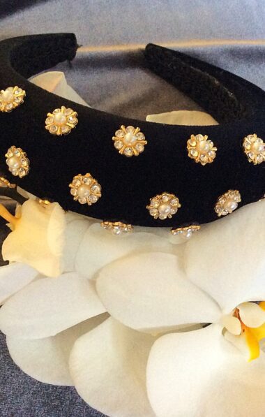 A padded headband with rhinestones and pearls
