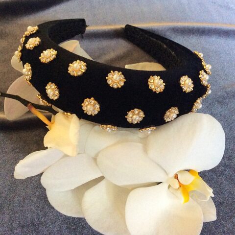 A padded headband with rhinestones and pearls