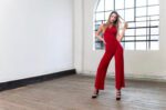 Model posing in an Red tango jumpsuit with sandals