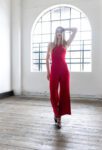 Model walking in a Red tango jumpsuit
