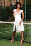 A woman in white dress at a tennis court