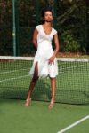A woman gives a pose at a tennis court